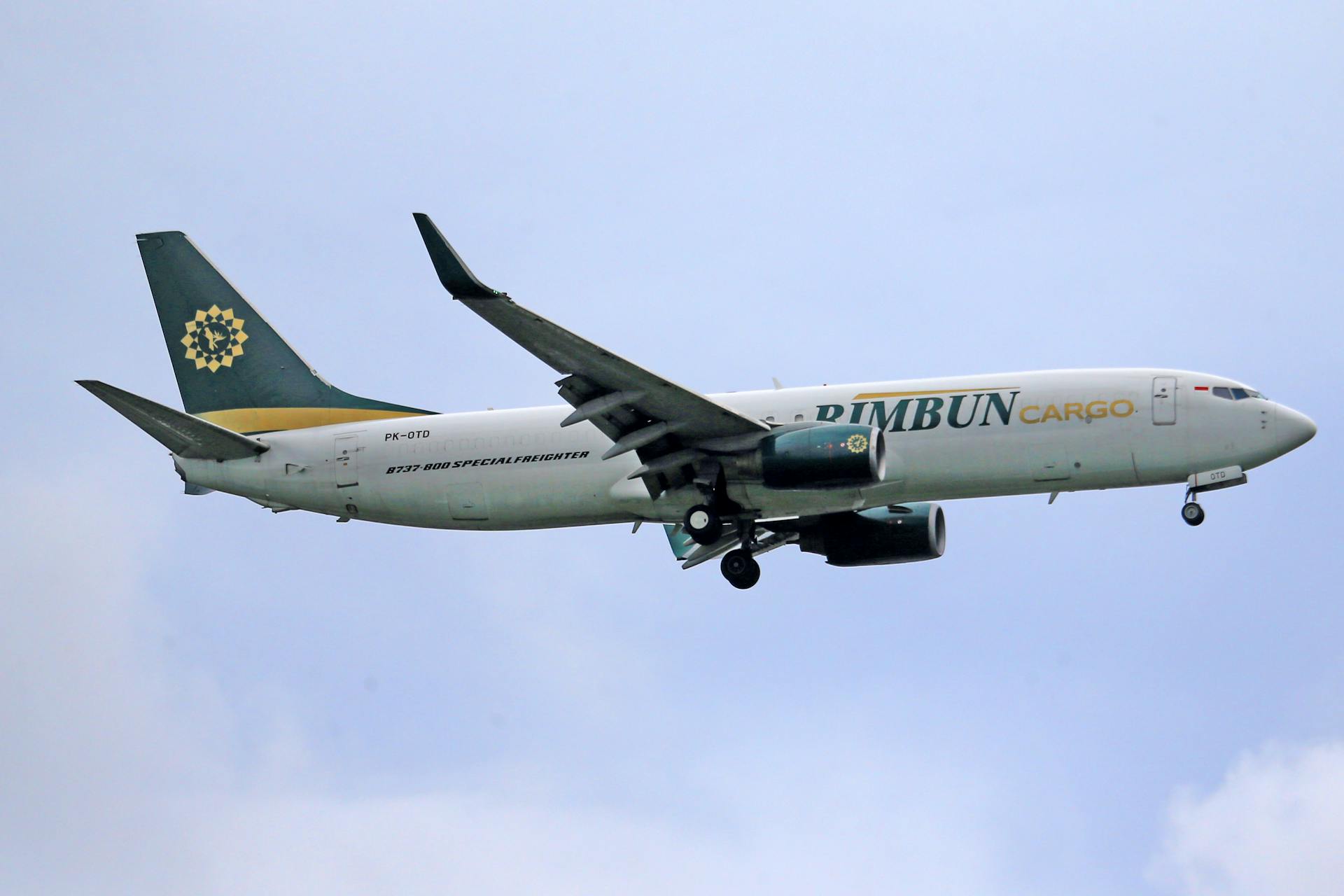 A Rimbun Cargo Boeing plane soaring through the sky, depicting freight transportation.
