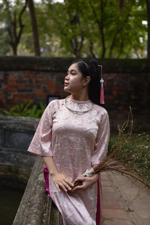 Woman in Traditional Clothing Sitting on Wall