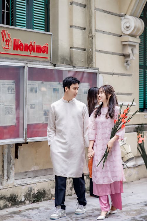 Foto profissional grátis de casal, de pé, flores