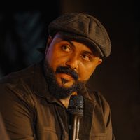 Speaker holding a microphone during a recorded session — photo by Nipin Niravath on Pexels