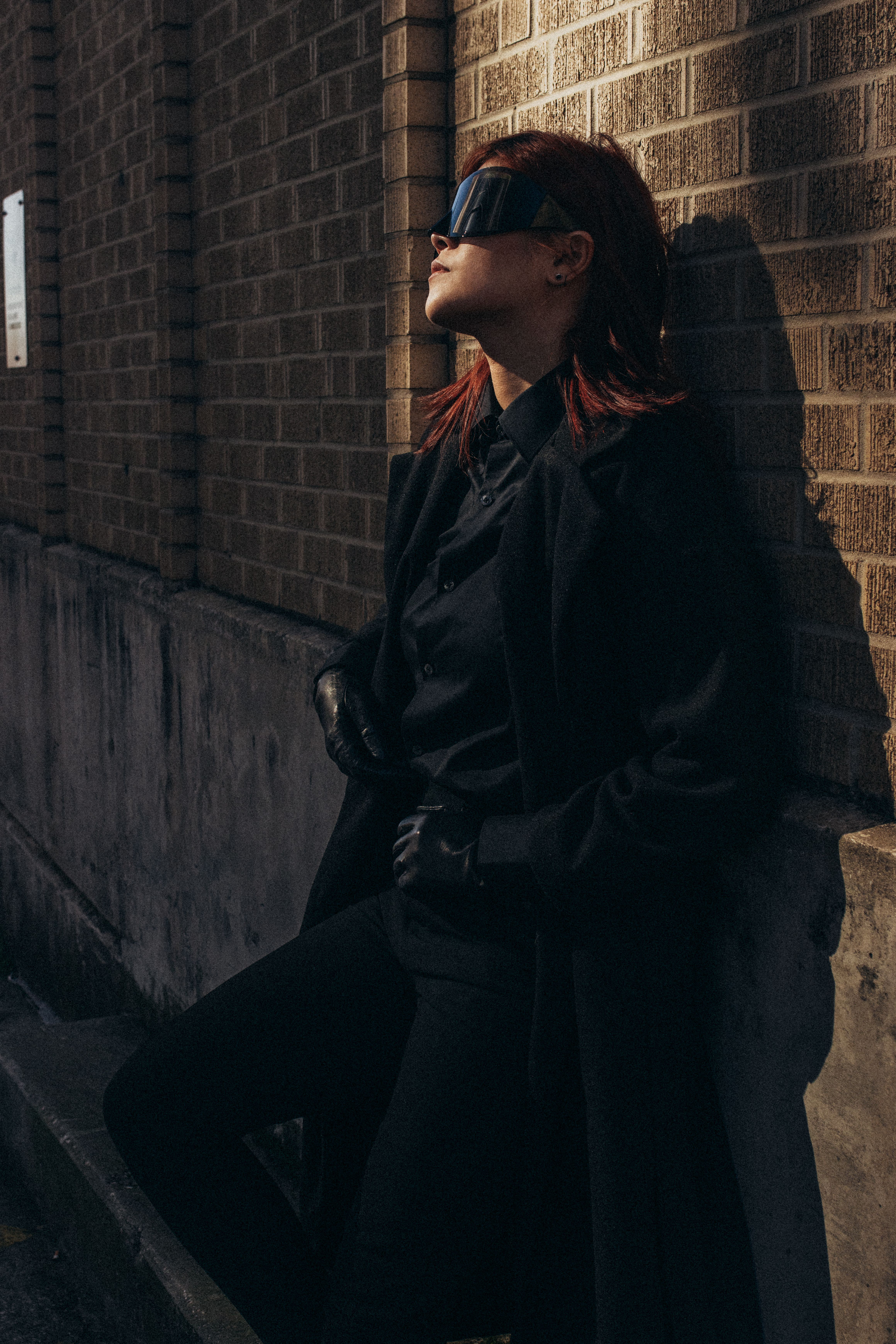Woman in Black Coat and Goggles Leaning on Wall · Free Stock Photo