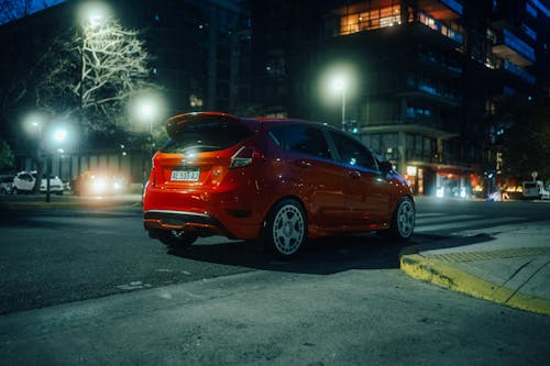 Foto profissional grátis de cair da noite, carro vermelho, cidade