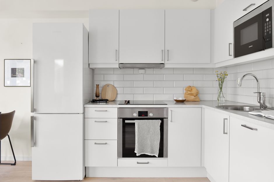 Sleek modern white kitchen featuring stylish appliances and minimalist design. Perfect for contemporary home inspiration.