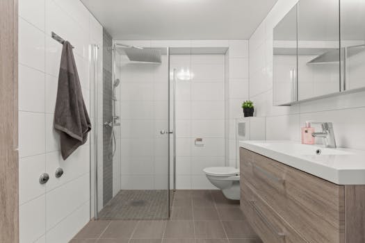 Sleek modern bathroom with glass shower, vanity, and minimalist decor.