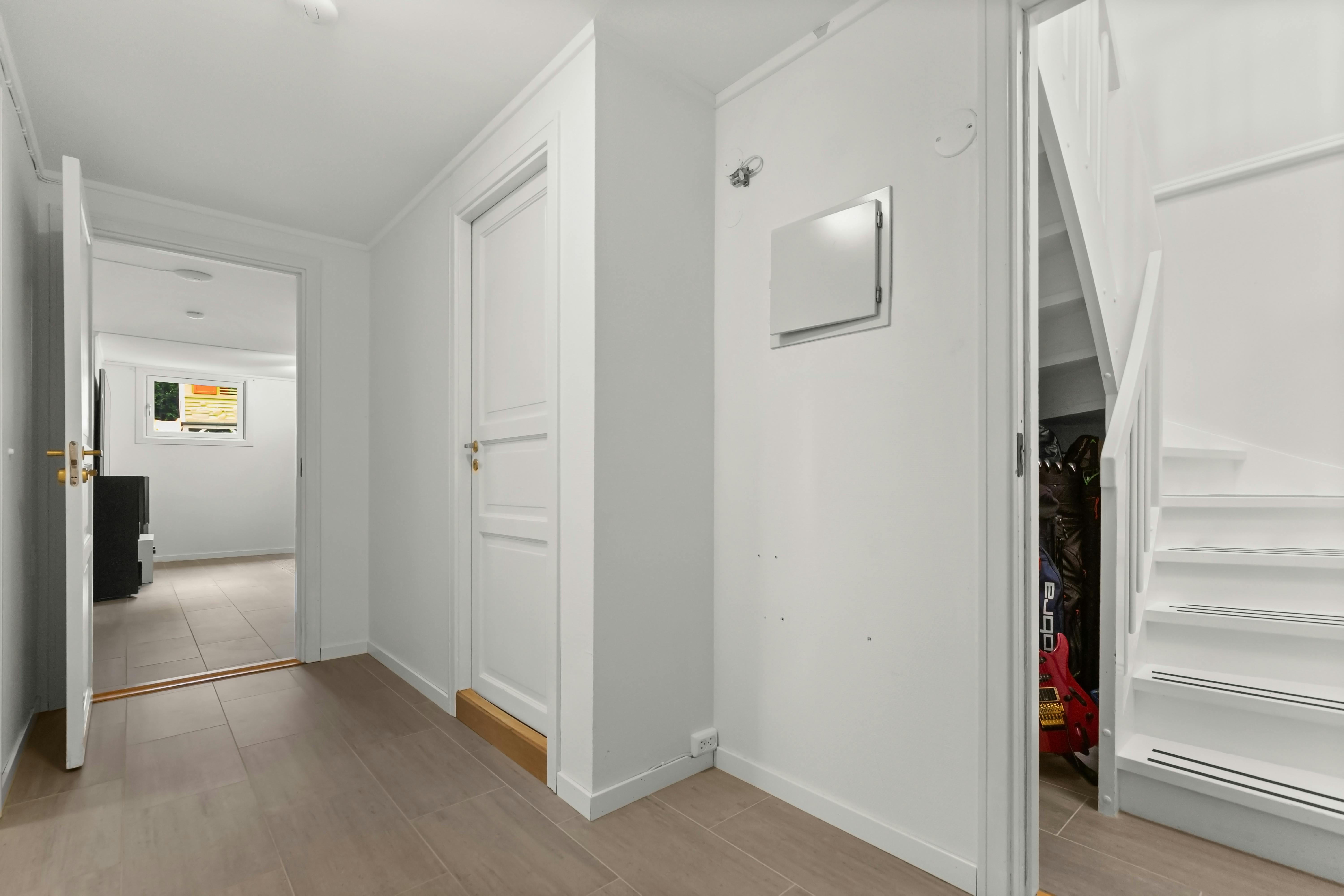 Nowoczesny korytarz w bloku z białymi drzwiami bezprzylgowymi i czarną klamką