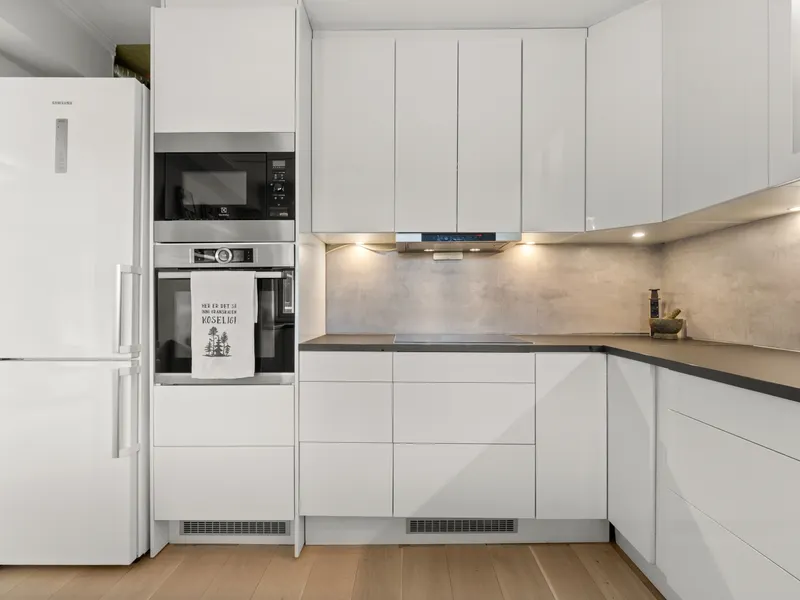 About our refrigerator repair team Sleek modern kitchen with white cabinetry and built-in appliances