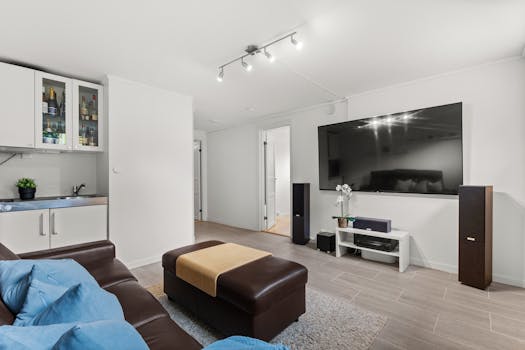 Spacious living room featuring a leather sofa, large TV screen, and contemporary decor.