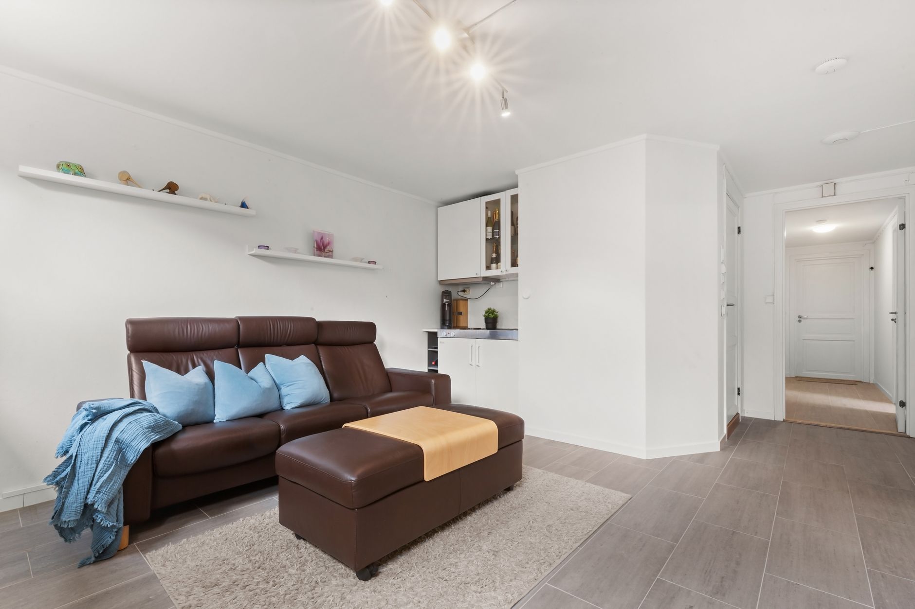 A polished rental-style living room that performs abundance without taking up much space.