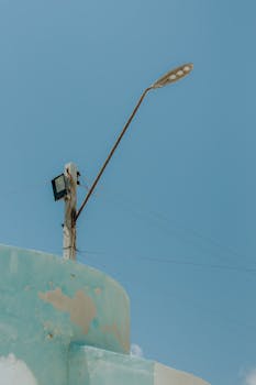 A minimalist view of a streetlight against a blue sky in Majorlândia, Brazil.