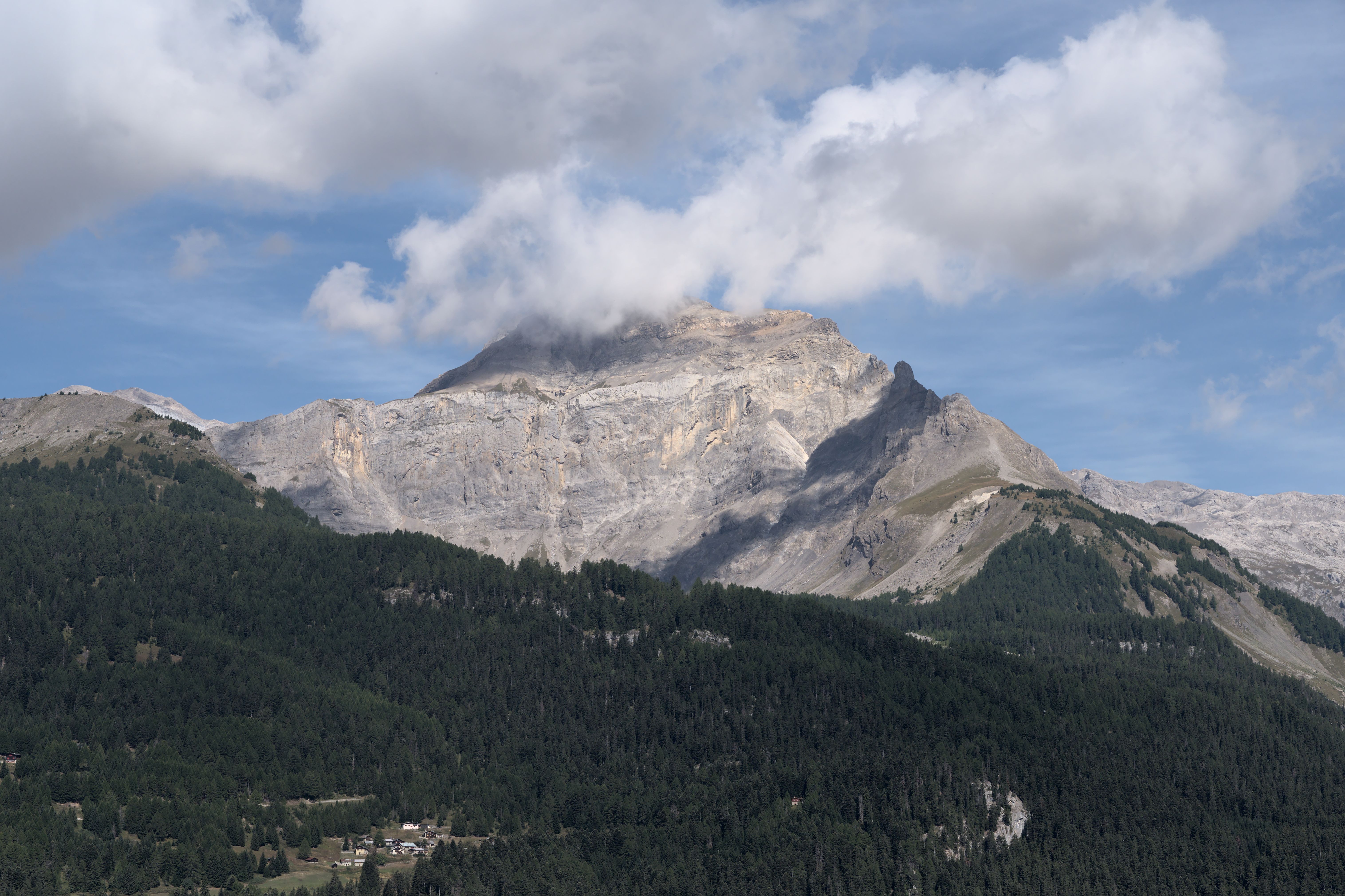 Breathtaking view of a Swiss Alps mountain range under a clear blue sky during summer.