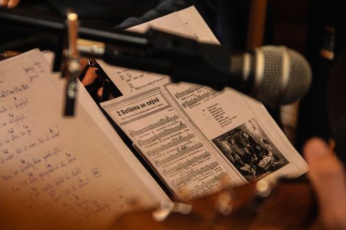 Free Close-up of sheet music with a microphone in a performance setting, capturing a musical moment. Stock Photo