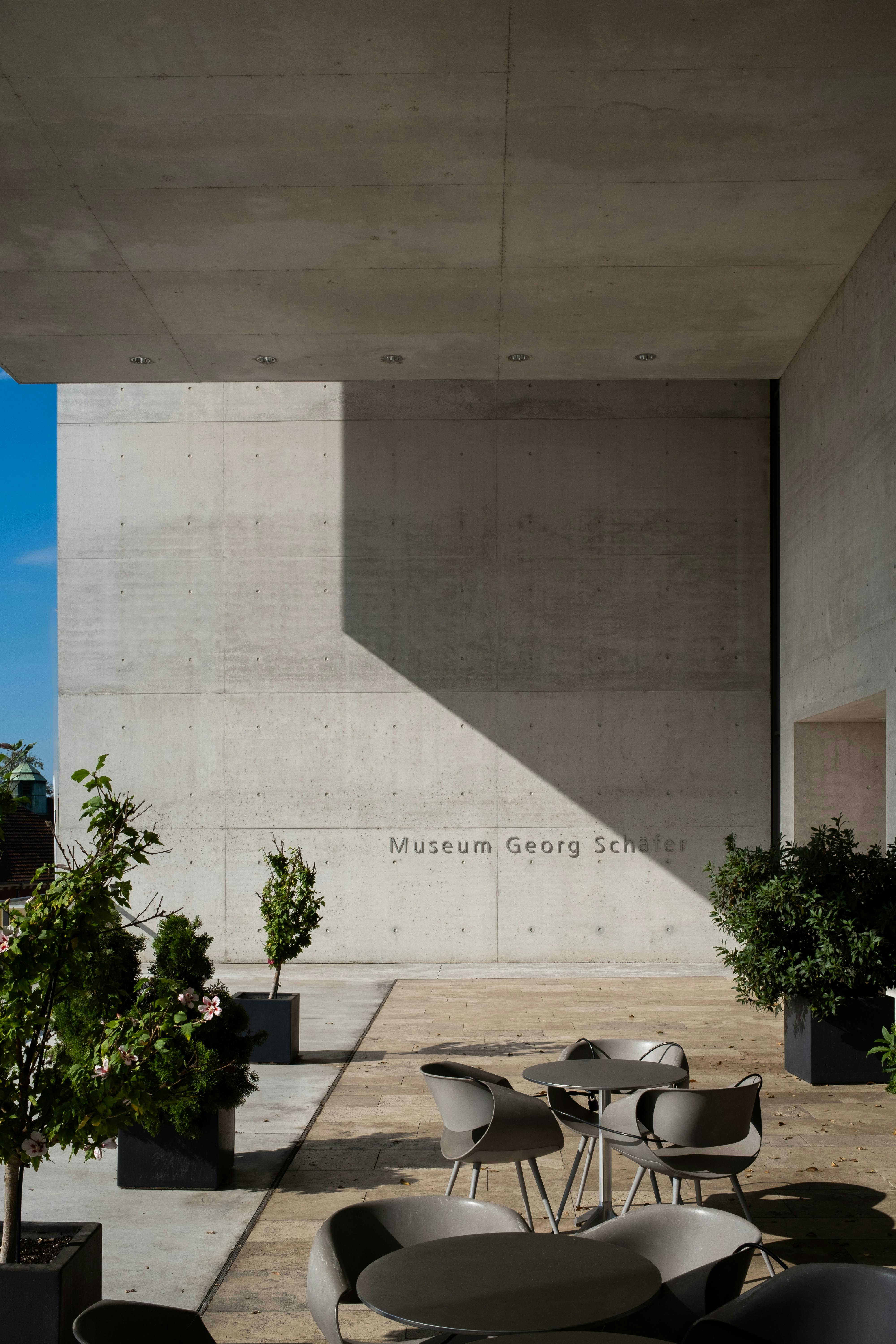 Contemporary view of Museum Georg Schaefer's minimalist exterior with seating area.