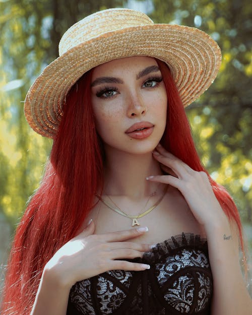 Free Photo of a Young Woman Wearing a Hat Standing Outside in Summer  Stock Photo