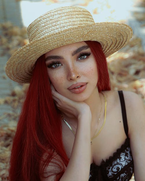 Photo of a Young Woman Wearing a Hat Posing Outside 