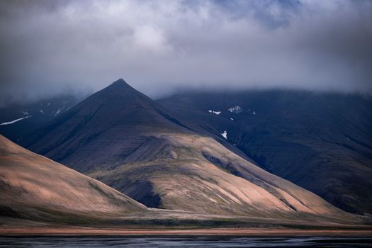 Serene mountain range under dramatic clouds, perfect for travel and nature themes.
