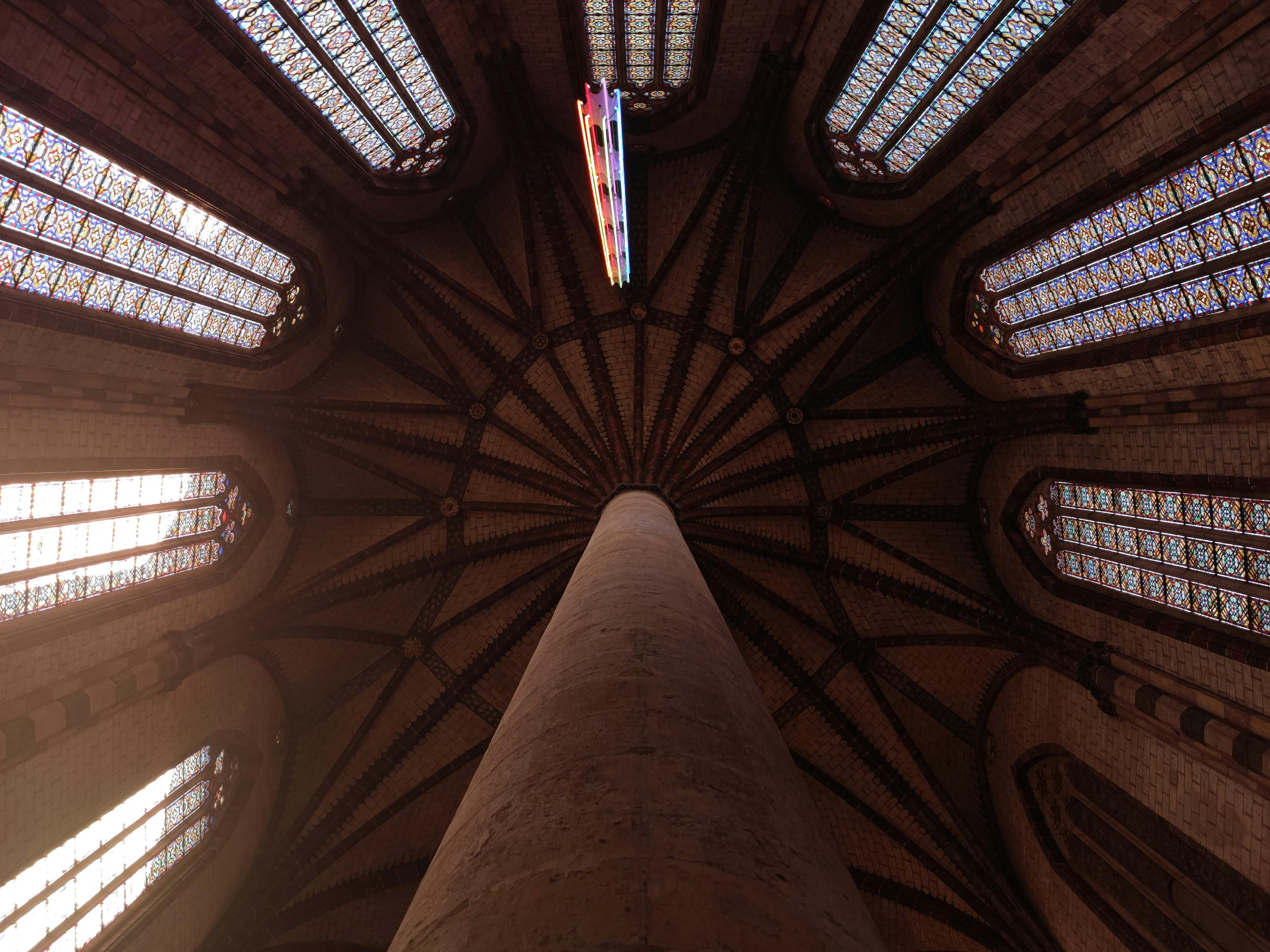 Stunning view of the Jacobins Church ceiling in Toulouse, France with colorful stained glass windows.