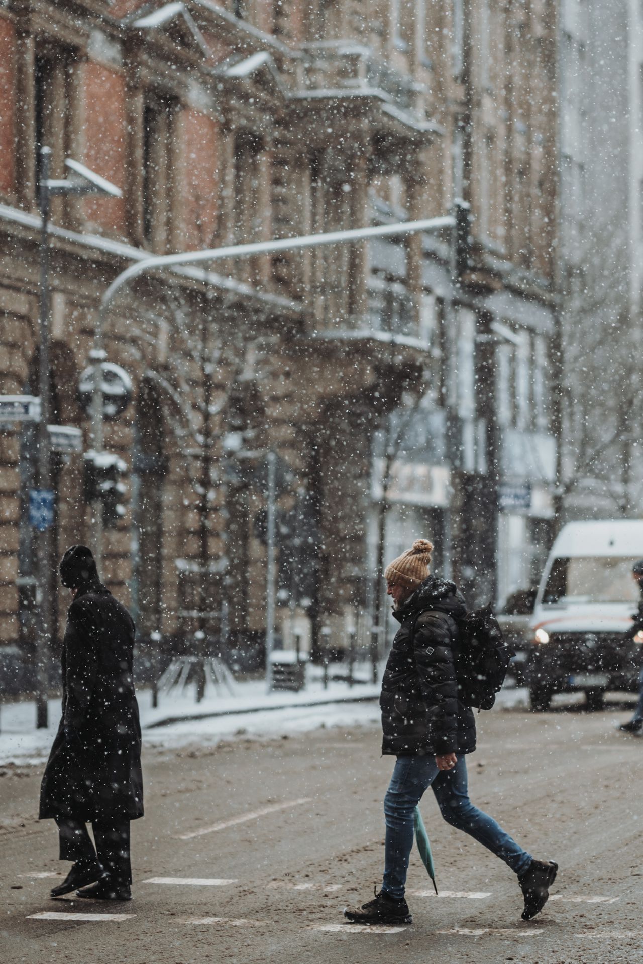 Pedestrians crossing a snowy city street