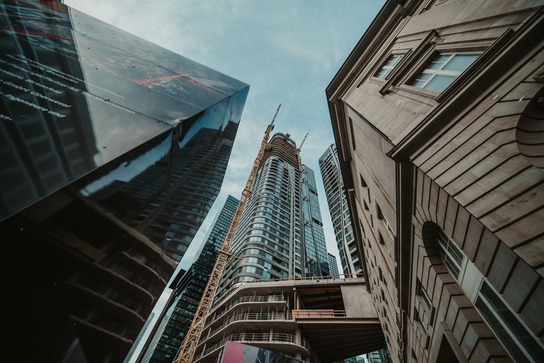 Upward view of modern skyscrapers in an urban setting with architectural diversity.