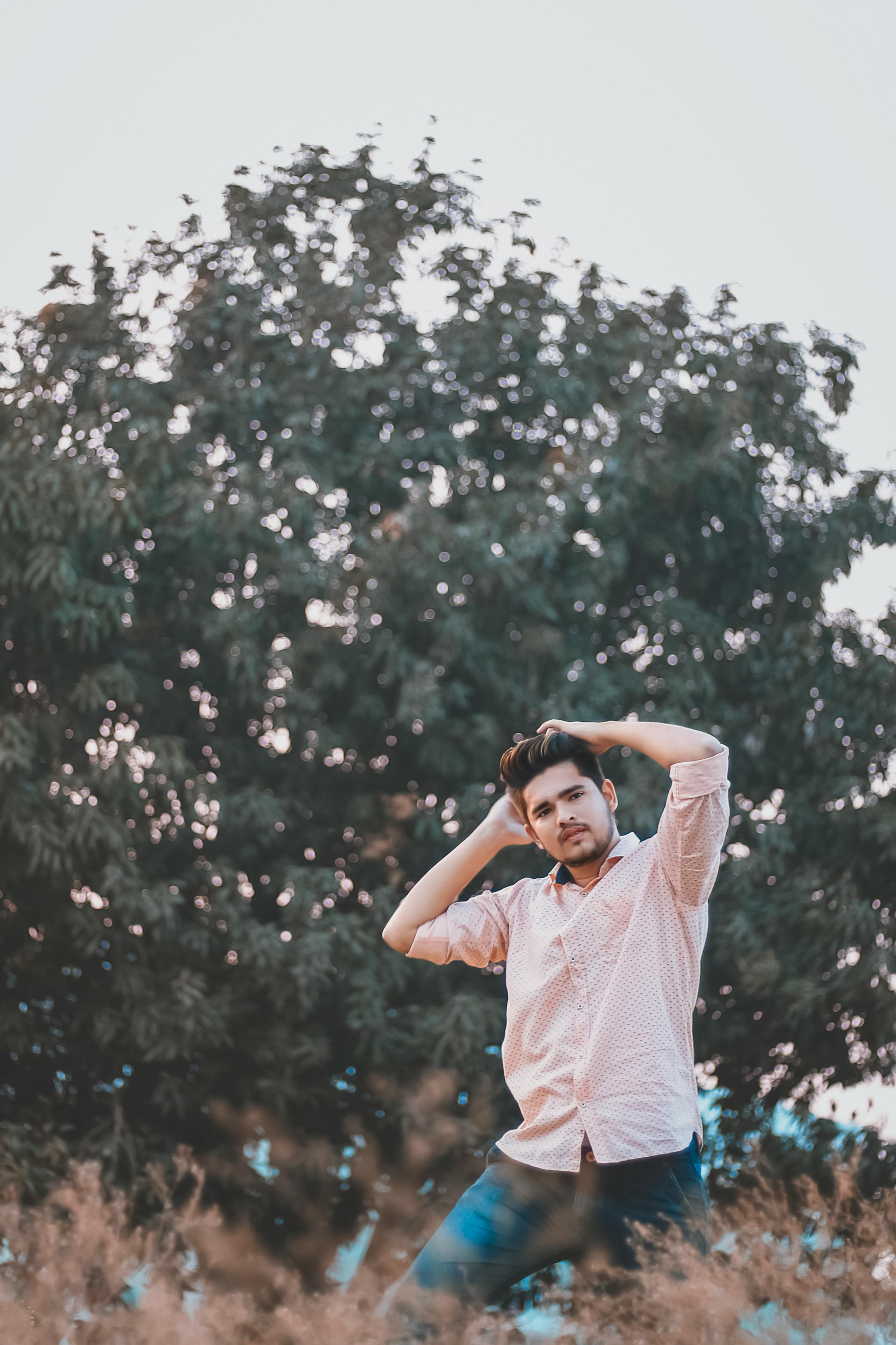 在孟买，年轻人在树木背景的户外时尚地摆姿势