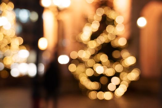 Blurred image of urban night with festive Christmas tree lights creating a bokeh effect.