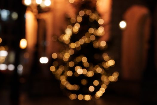 Abstract bokeh of festive Christmas tree lights creating a warm urban holiday atmosphere at night.