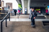 年轻的滑板手在桥下色彩缤纷的城市滑板公园里表演特技