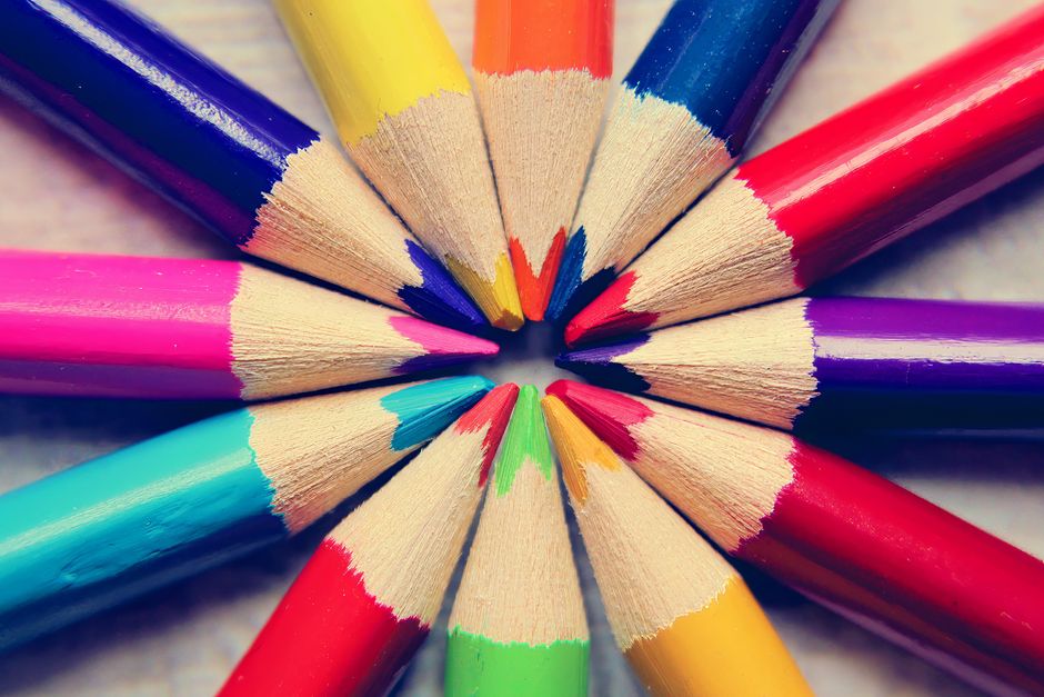A bright and cheerful circular arrangement of various colored pencils on a light surface.