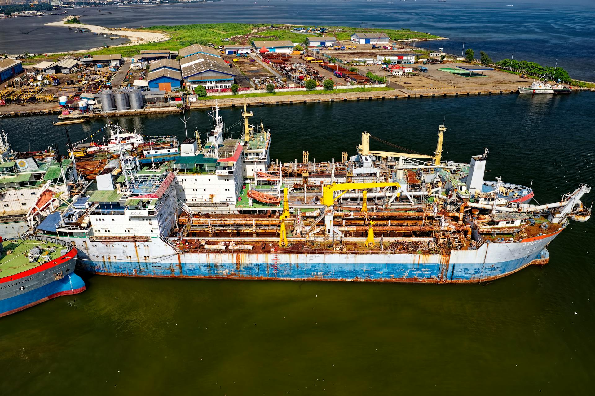 Aerial view of a bustling industrial port showcasing ships, warehouses, and docks.