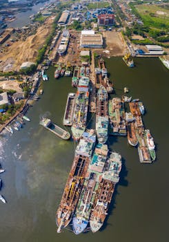 Aerial shot of a busy shipyard in Indonesia with multiple ships docked for repair.