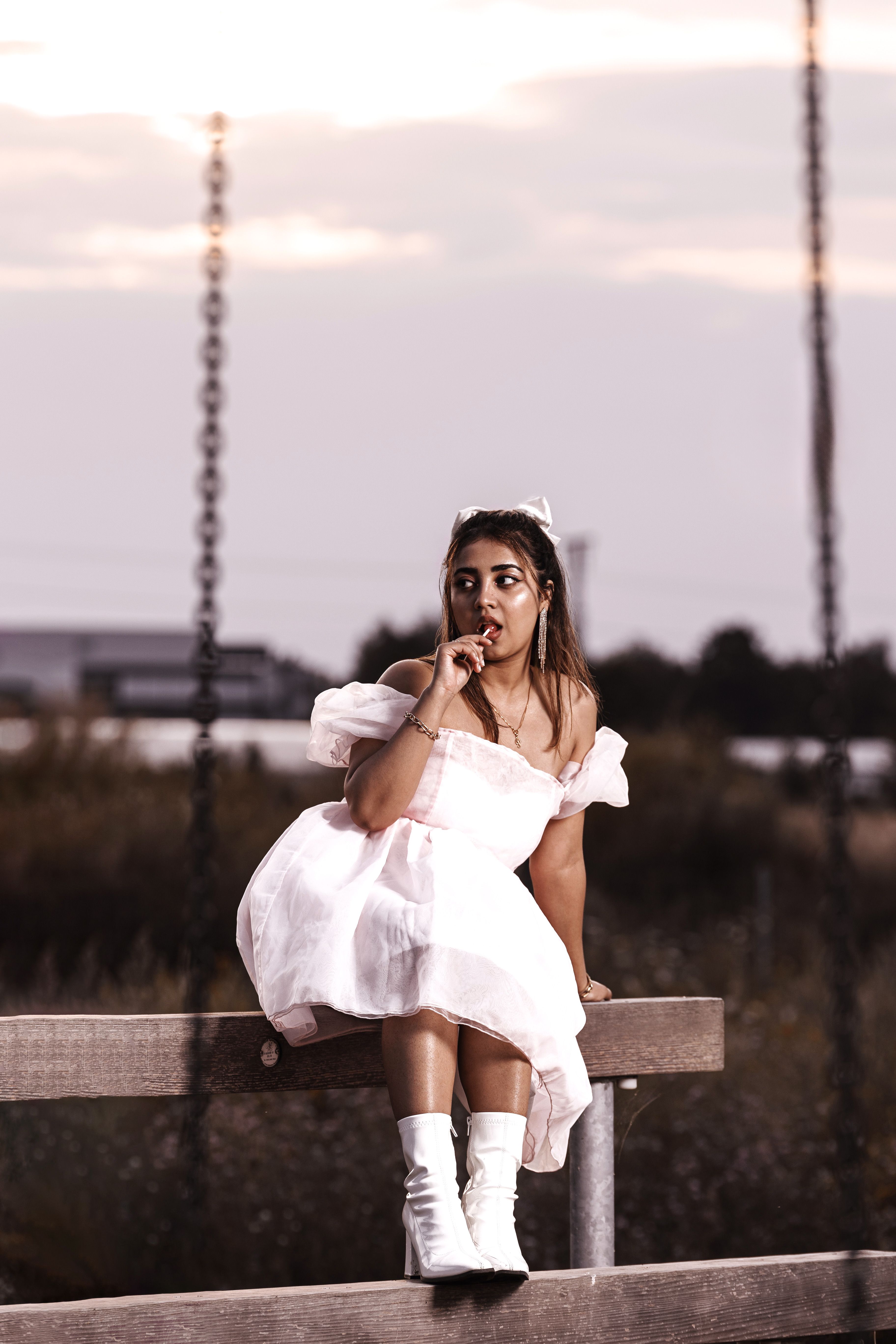 Woman in White Dress Sitting with Lollipop on Bench · Free Stock Photo
