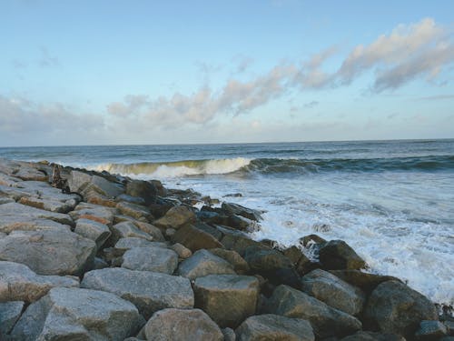 Breakwater with crashing waves and a beautiful view of the beach in the monsoon season.