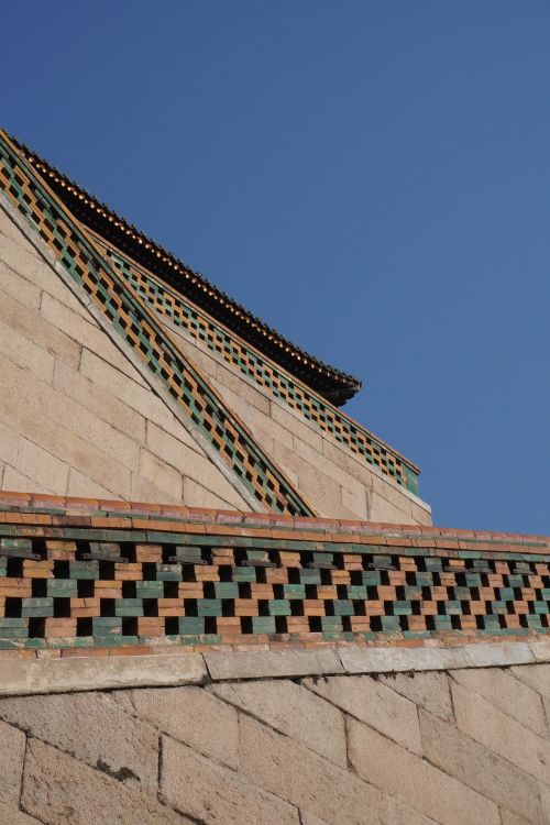 Free Close-up of a sunlit architectural facade with intricate design and a clear blue sky backdrop. Stock Photo