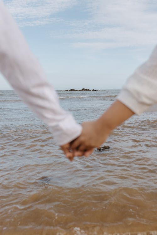 Couple Holds Hand by Sea