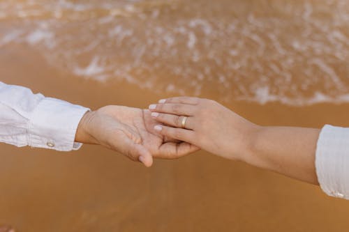 Couple Holds Hands over Beach