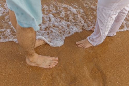 Sea Washes Feet of Couple