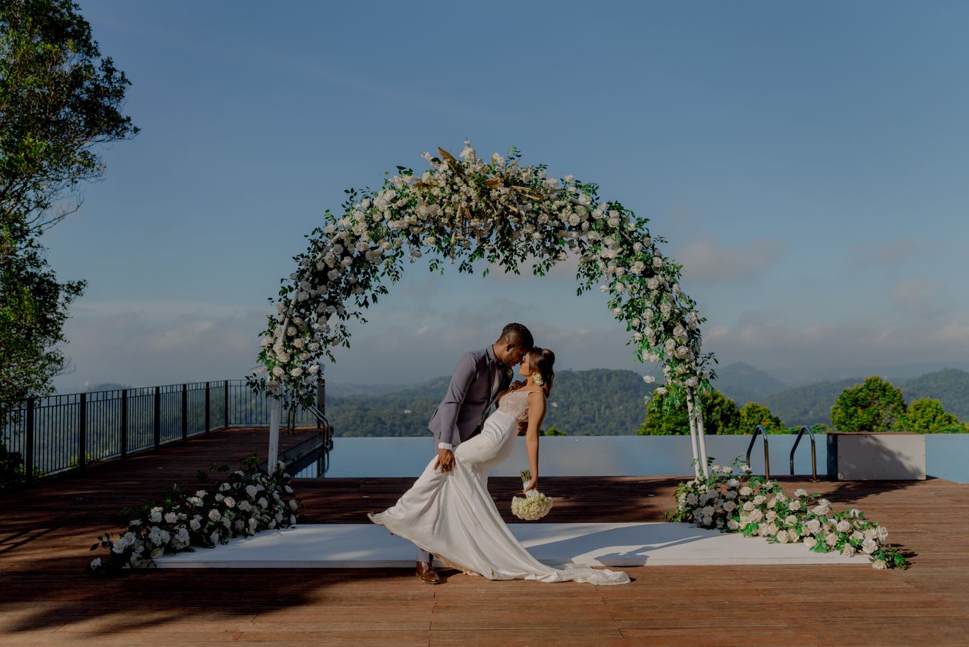 Bride and groom beneath a luxury floral wedding arch