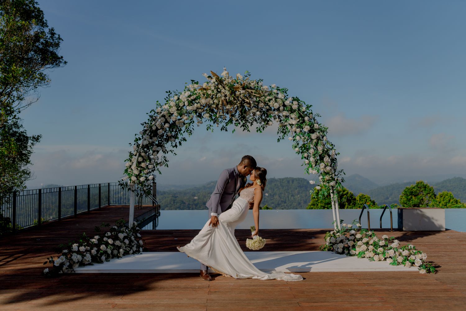 Bride and groom under a luxury floral wedding arch