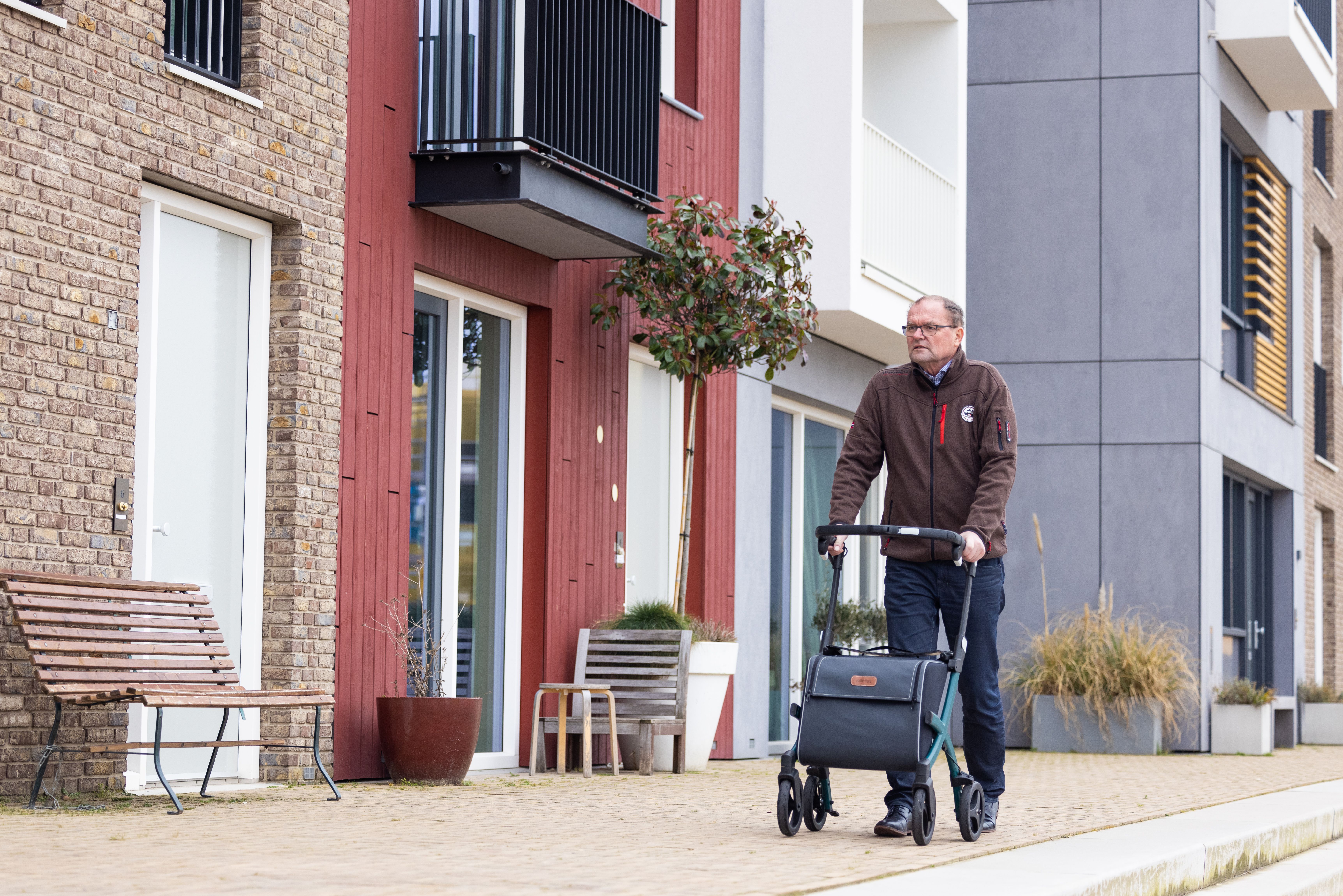 Personne âgée poussant un déambulateur sur un trottoir