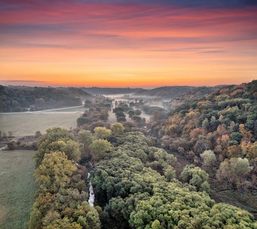 An aerial view of a river and trees in the fall