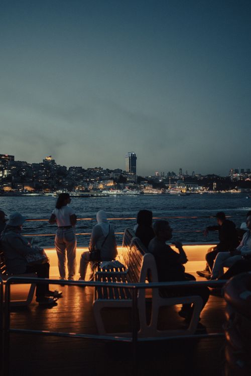 Free Experience a serene evening ferry ride with the İstanbul cityscape in view under a twilight sky. Stock Photo