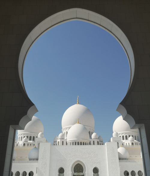 Free Captivating view of the Sheikh Zayed Grand Mosque's domes framed by an archway in Abu Dhabi. Stock Photo