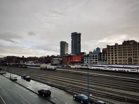 Moody view of Vancouver's skyline with railway tracks on a rainy day.