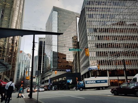 Modern urban street view of downtown Vancouver with glass skyscrapers and traffic.