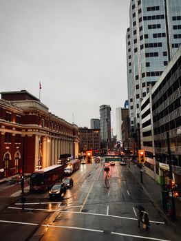 A bustling city street scene in Vancouver under rainy weather, capturing traffic and urban life.
