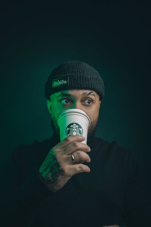 Portrait of Man in Hat and Drinking Coffee from Starbucks