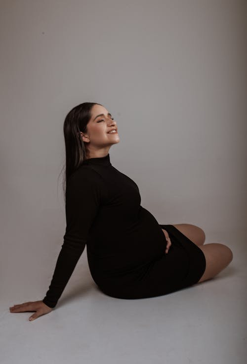 Studio Shot of a Pregnant Woman Wearing a Black Dress 