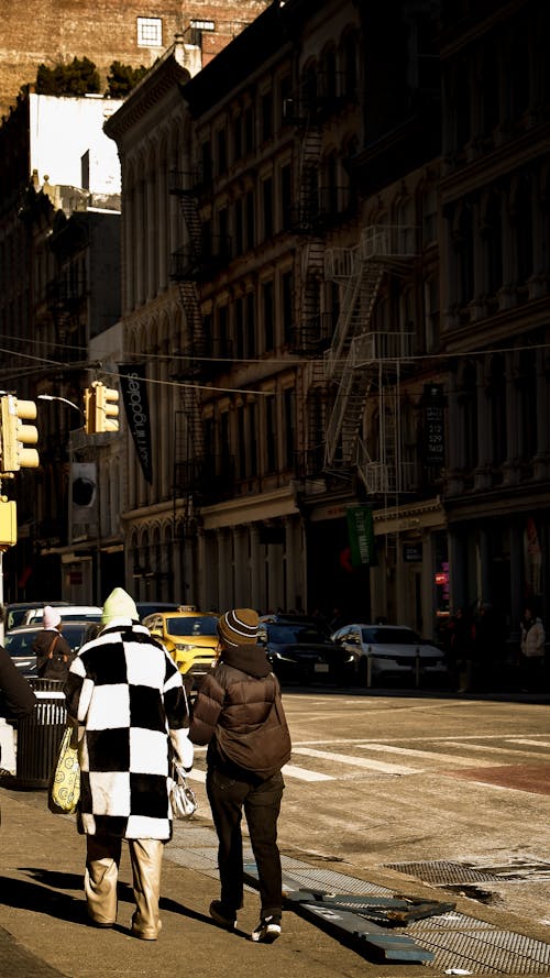 A couple walking down the street in a checkered jacket