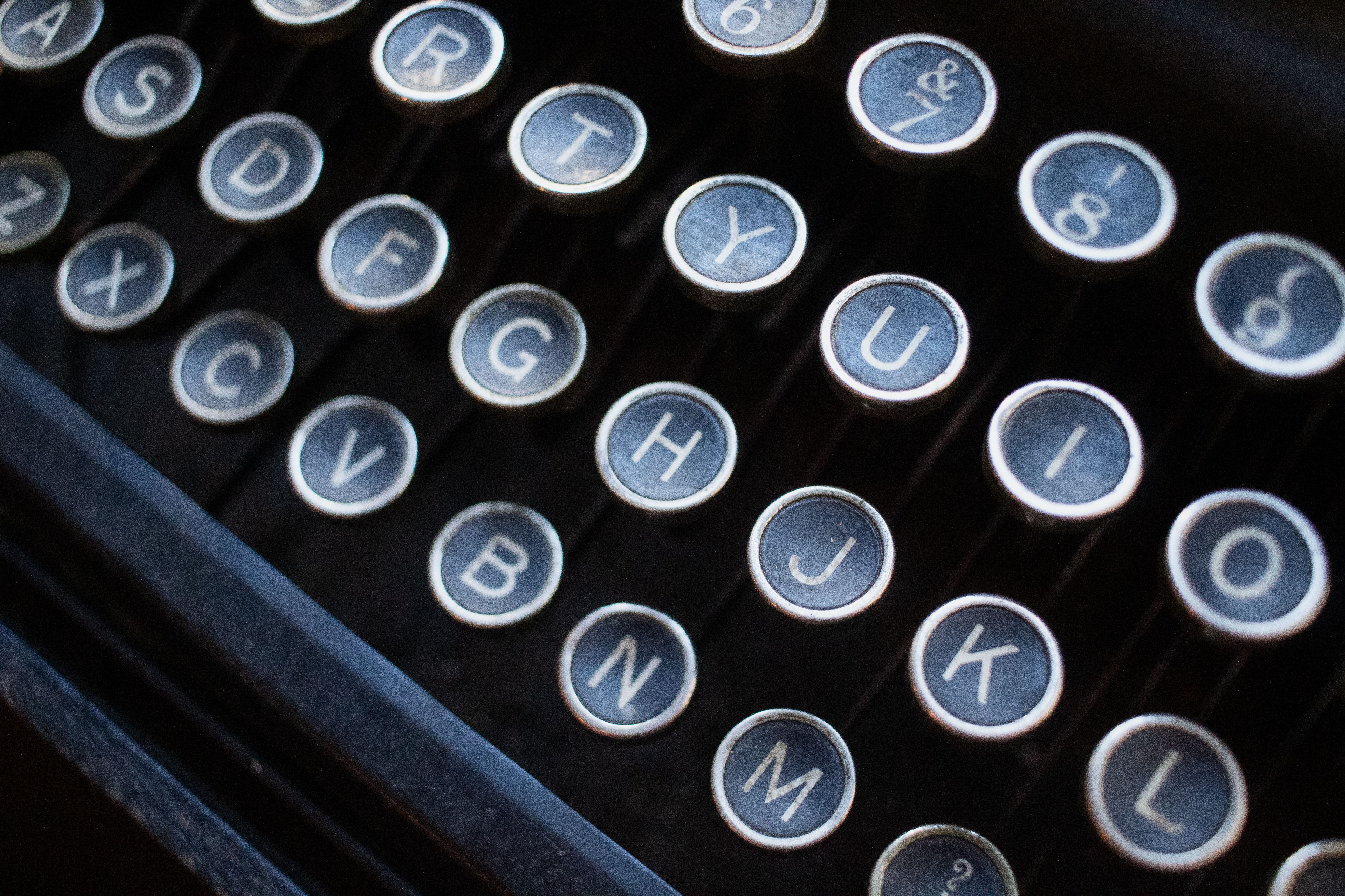 A close up of a typewriter with the letters on it