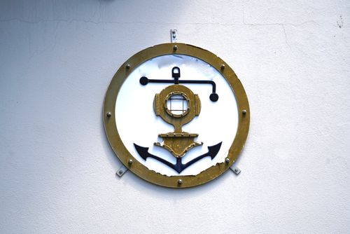Free A vintage diving helmet and anchor decoration on a white wall, maritime themed. Stock Photo
