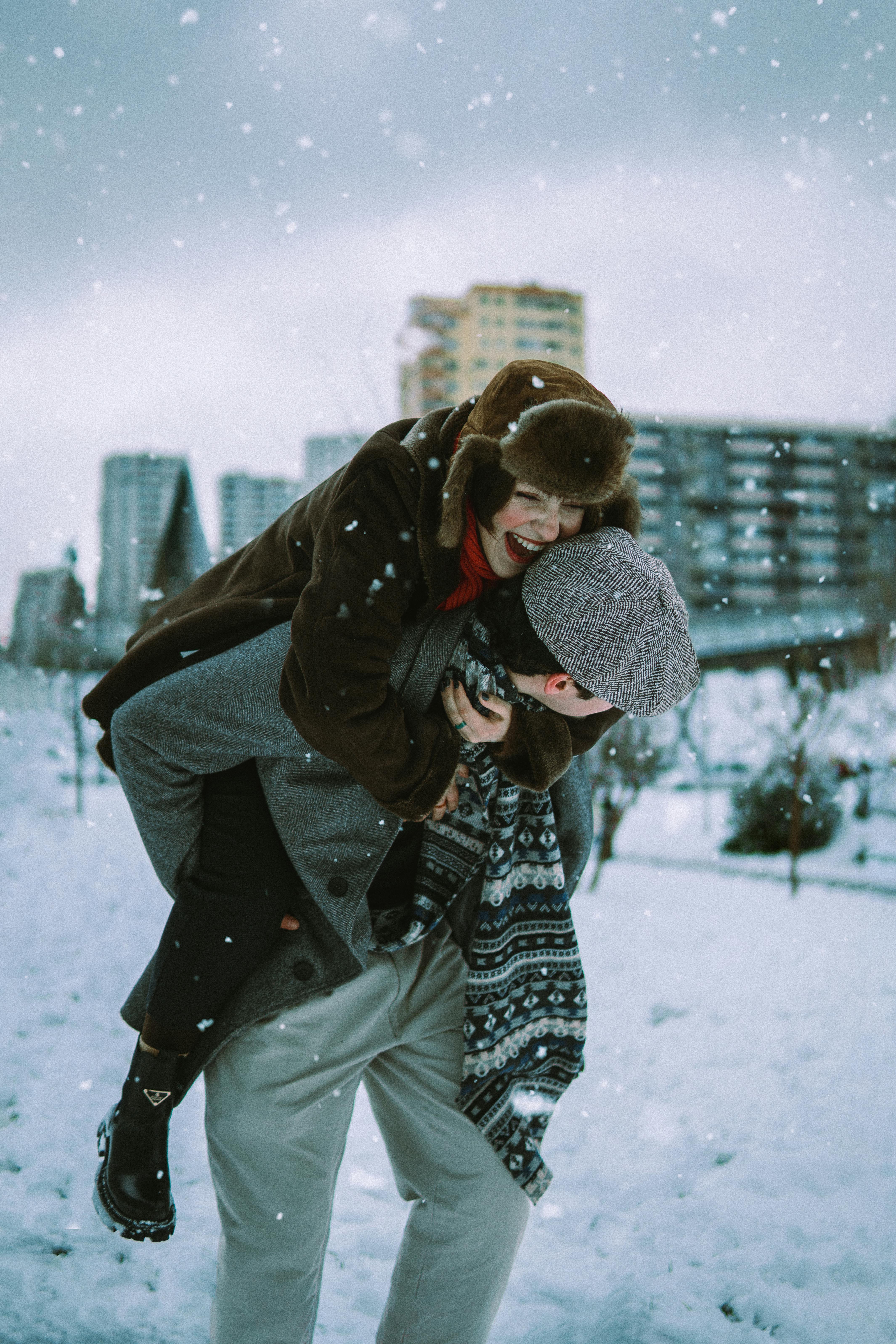 Smiling couple enjoying winter snow in Baku, Azerbaijan.